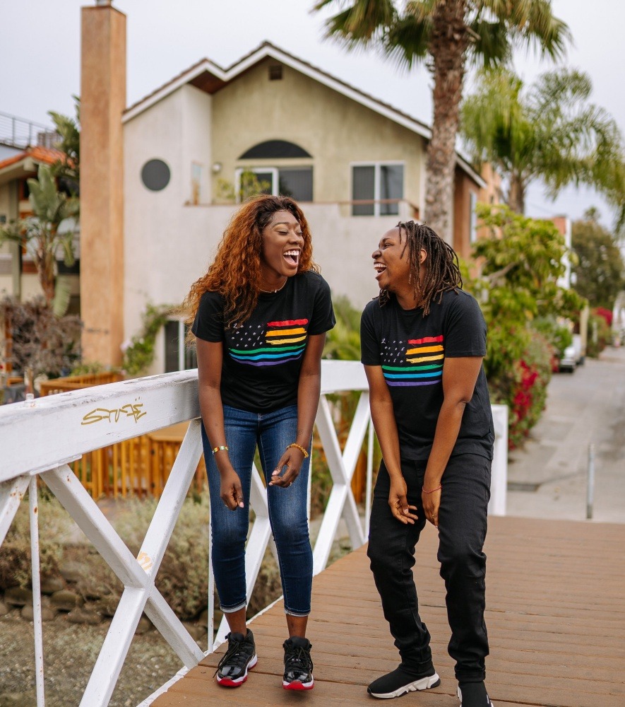 Two ladies laughing wearing PRIDE shirts