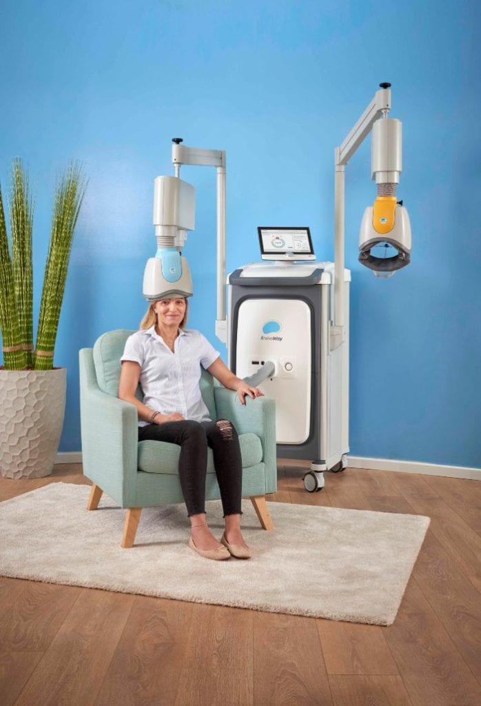 blonde woman experiencing TMS treatment