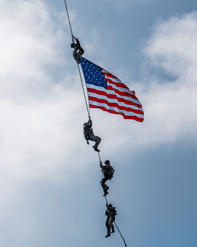 US soldiers performing with flag from helicopter